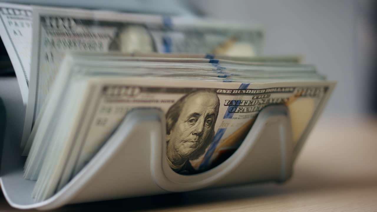 equipo bancario que cuenta billetes de dólar de cerca. cálculo de la moneda estadounidense
