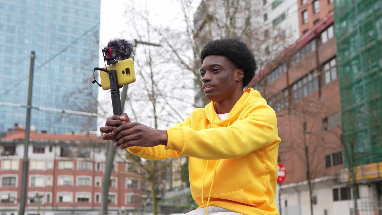Uomo con taglio di capelli afro che fa un vlog in città