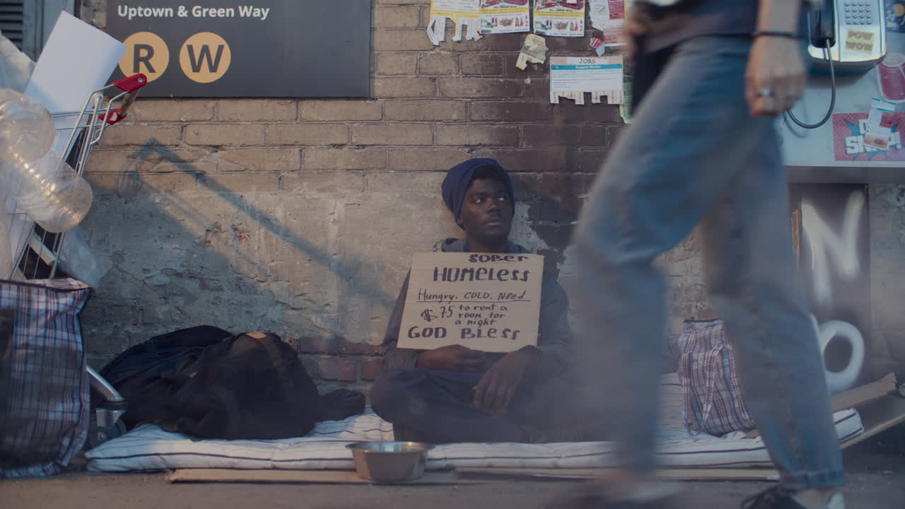 Beggar with Sign Sitting on Street, Asking for Help near Subway