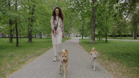 woman walking dogs in park