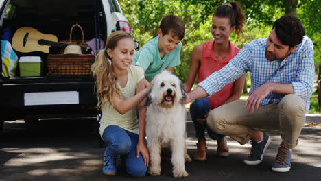 Familie-Sitzt-Mit-Ihrem-Hund-Im-Park