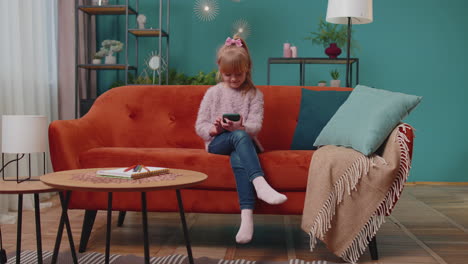 niña infeliz jugando en el teléfono móvil escribiendo navegación, pierde juego en línea, malas noticias, fracaso, pérdida