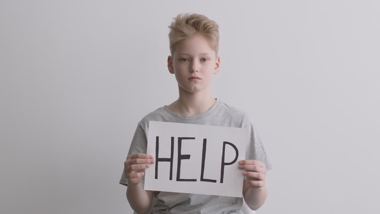 Boy Holding a Sign Saying Help