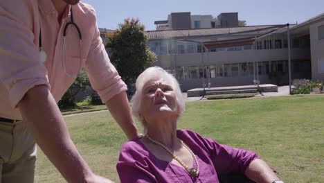médico con una mujer mayor en el parque de un hogar de ancianos