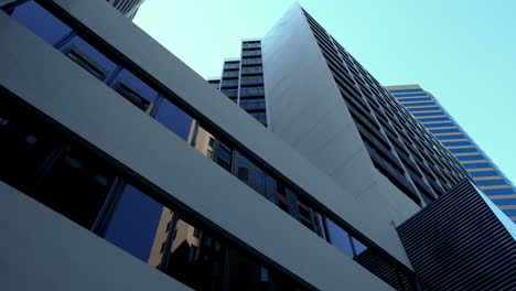 the low angle panning view of the city skyline buildings and blue sky
