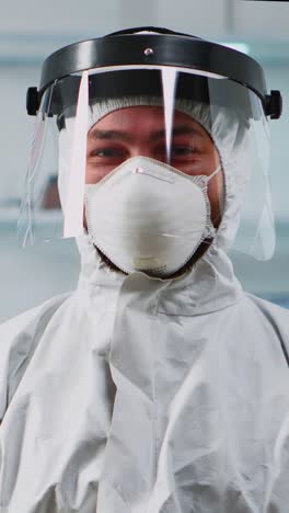 vertical video: scientist man wearing coverall smiling at camera