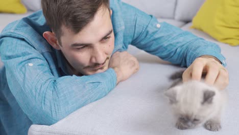 the man caresses his cat, loves and spends time.