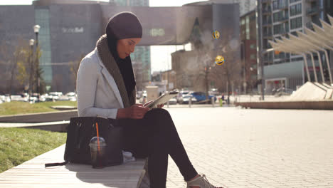 animación de una mujer de raza mixta con hijab en la calle usando una tableta con emoji flotante