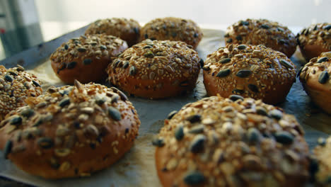 Baked-buns-topped-with-mixed-seeds-placed-on-tray-4k