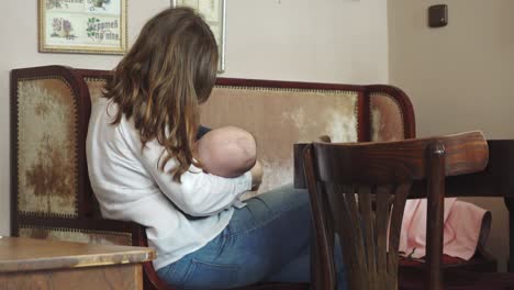 a woman breastfeeding her child in a cafe