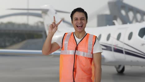 happy indian airport ground staff showing victory sign
