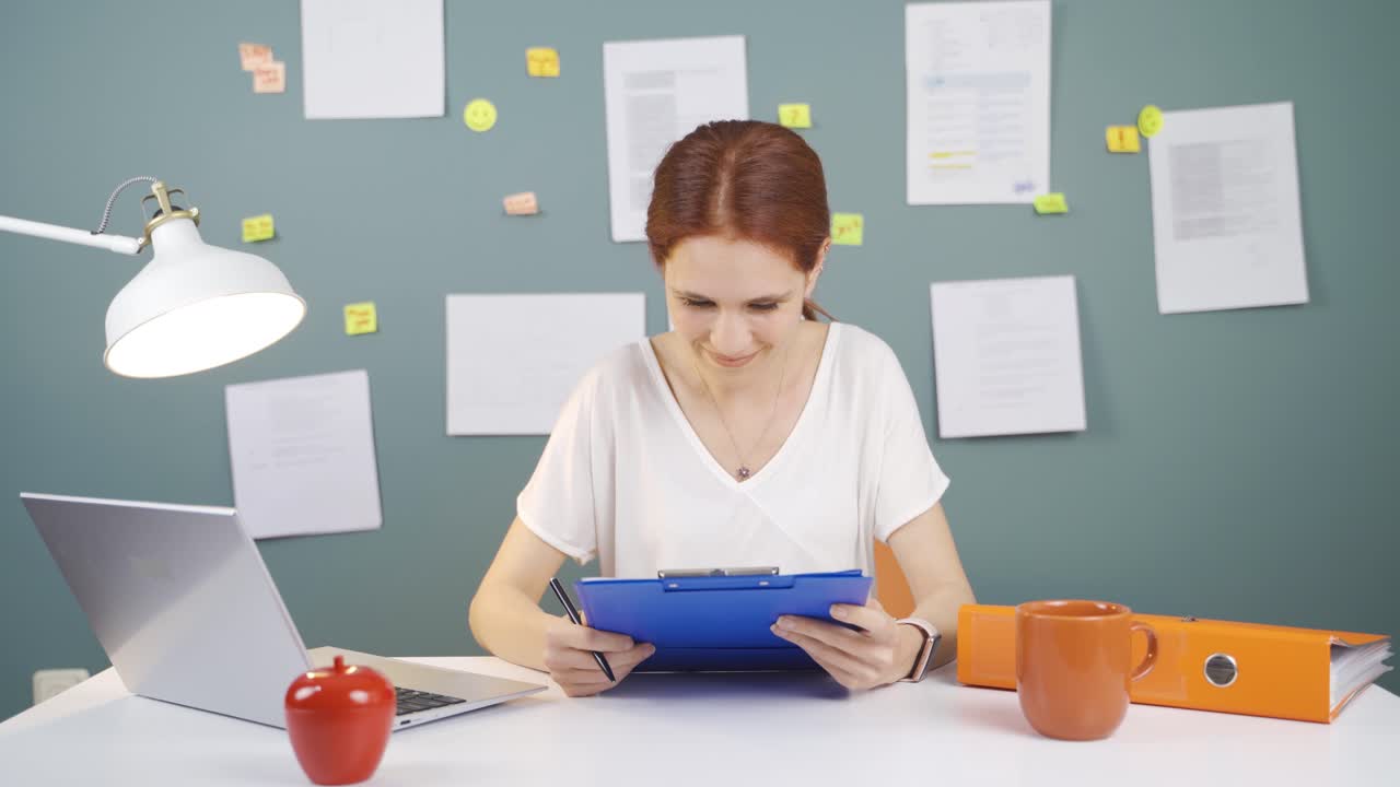 la mujer que revisó y firmó el papeleo está feliz y satisfecha.