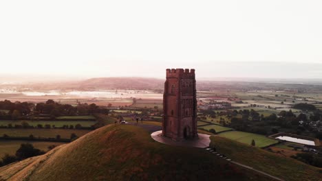 panning early morning sunrise over glastonbury tor and the misty fields, somerset