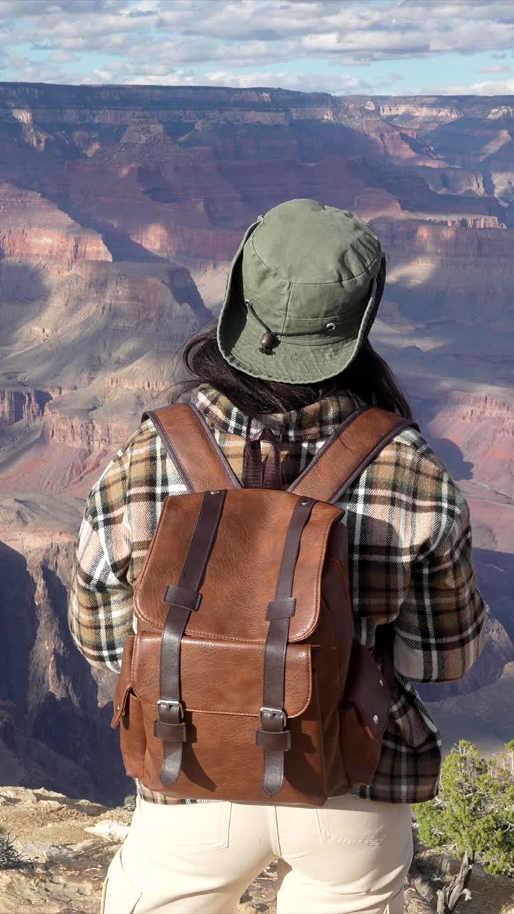Donna con lo zaino che si gode la vista del Grand Canyon e sorride
