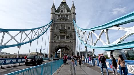 people walking and vehicles crossing tower bridge