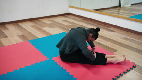 woman warms up her muscles before teaching dance class students
