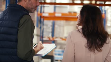 two caucasian workers walking thru the warehouse