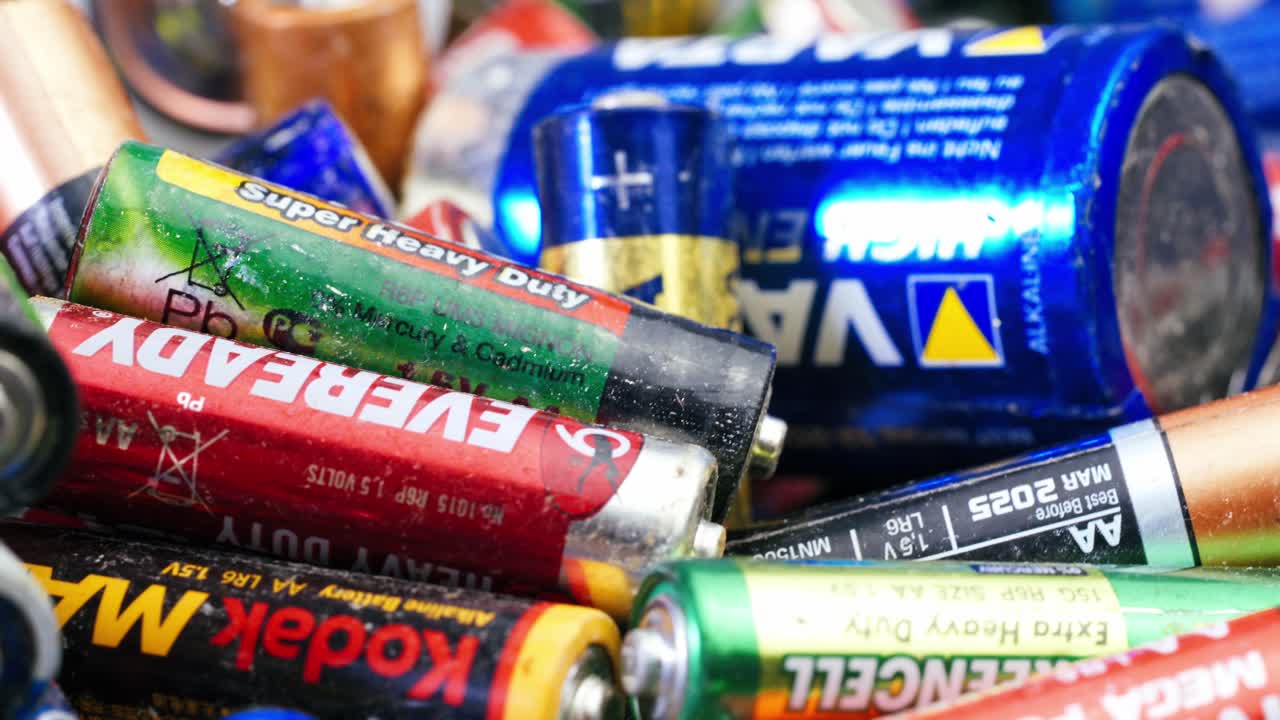 Used batteries from different manufacturers, waste, collection and recycling, high danger for the environment. Batteries background