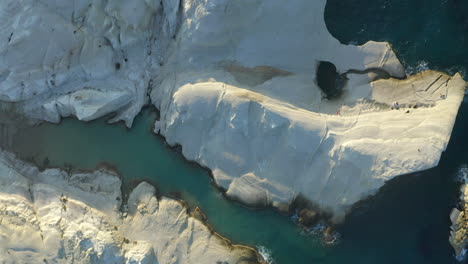 Topdown-Aerial-Drone-footage-of-Sarakiniko-Beach-in-Milos-Island,-Greece-at-sunset-in-4K