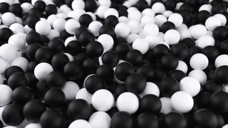 black white 4k 3d animation from a pile of abstract spheres and balls rolling and falling from top to bottom.