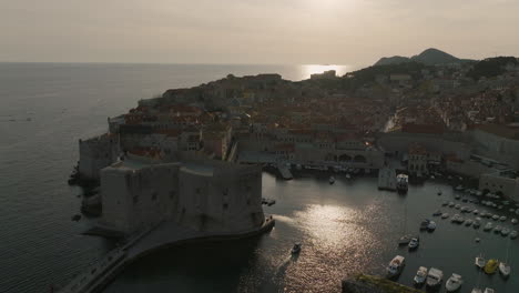 Drone-Aéreo-De-5k-Sobre-La-Fortaleza-De-Dubrovnik-Junto-Al-Mar-Y-El-Puerto-Deportivo-De-Barcos-En-La-Brillante-Luz-Del-Sol-De-La-Tarde-En-Croacia