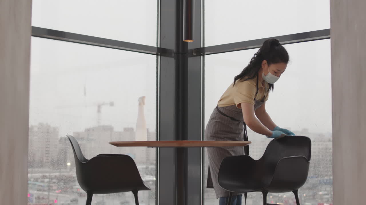 Asian Woman Disinfecting Chair in Restaurant