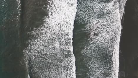 aerial view of waves crashing onto the shore in dominical beach in costa rica, static top down