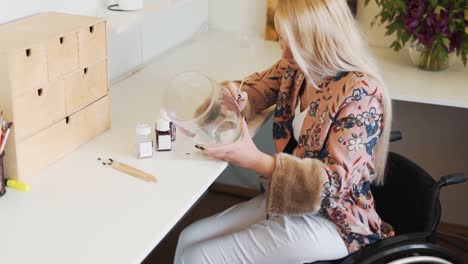 A-woman-in-a-wheelchair-paints-dishes