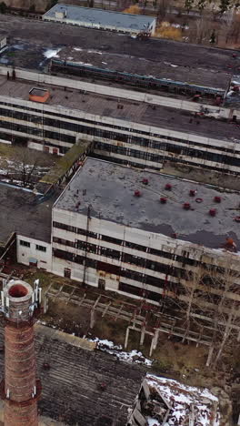 old industrial zone with ruined buildings. empty abandoned factory with brick edifices in place. large aged enterprise. top view. vertical video