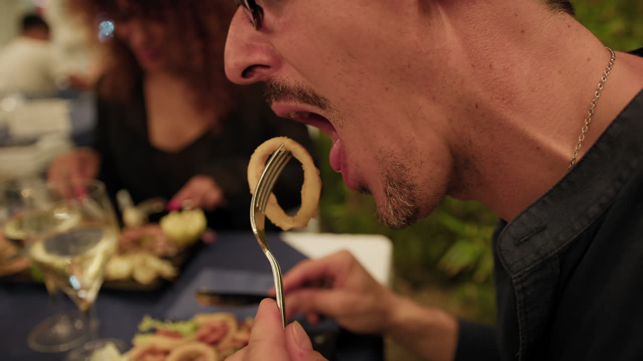 Man Eating Fried Squid Rings During A Romantic Dinner At The Restaurant