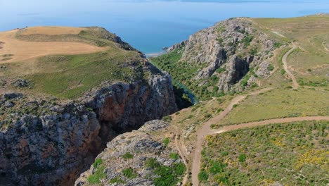río que fluye hacia el océano azul a través del valle de las montañas rocosas, creta