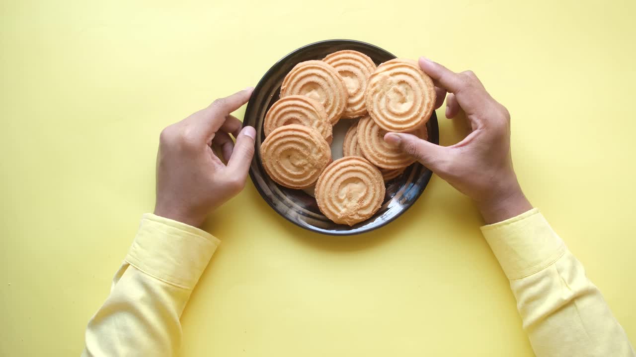 접시 에 있는 쿠키 를 잡기 위해 손 을 는 것