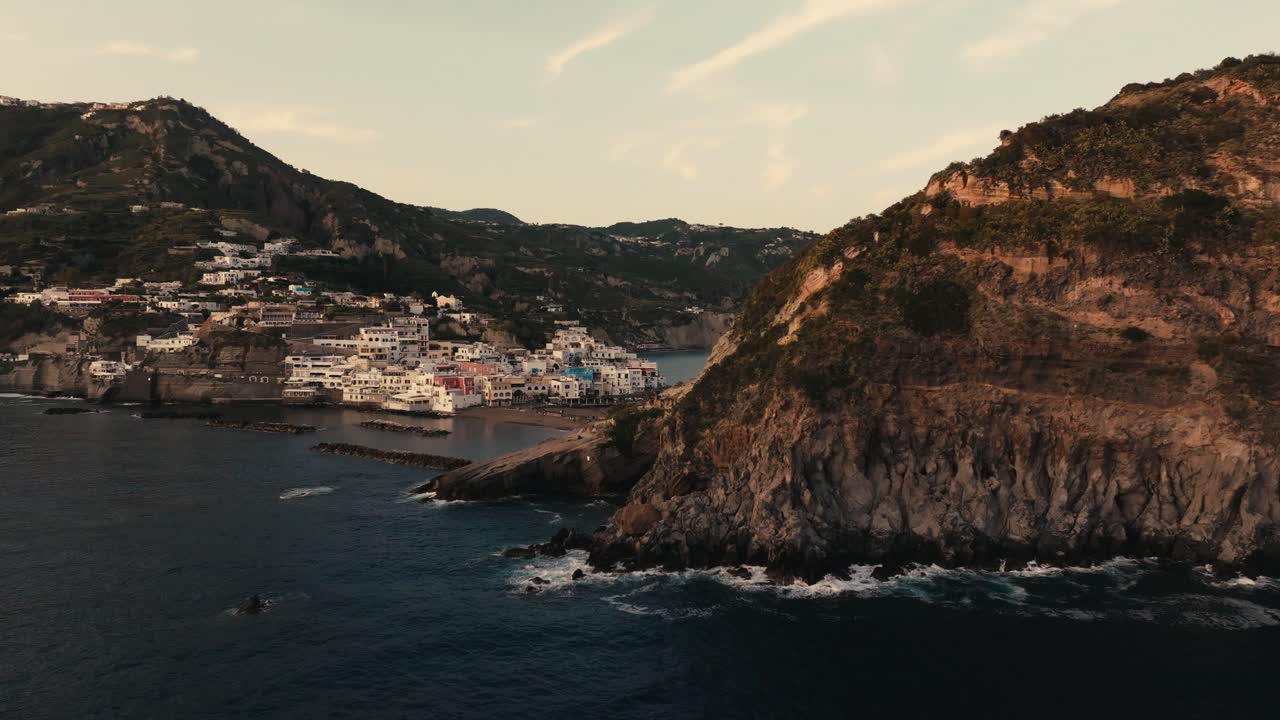 Sant&rsquo;Angelo town and seaside cliffs at Ischia, sunset aerial push-in