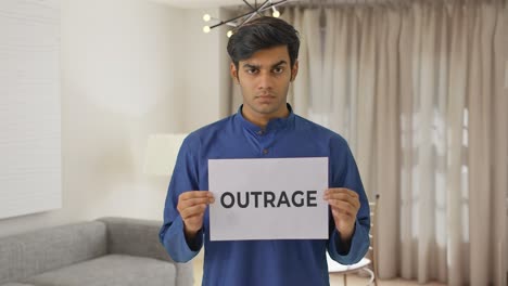 angry indian boy holding outrage banner