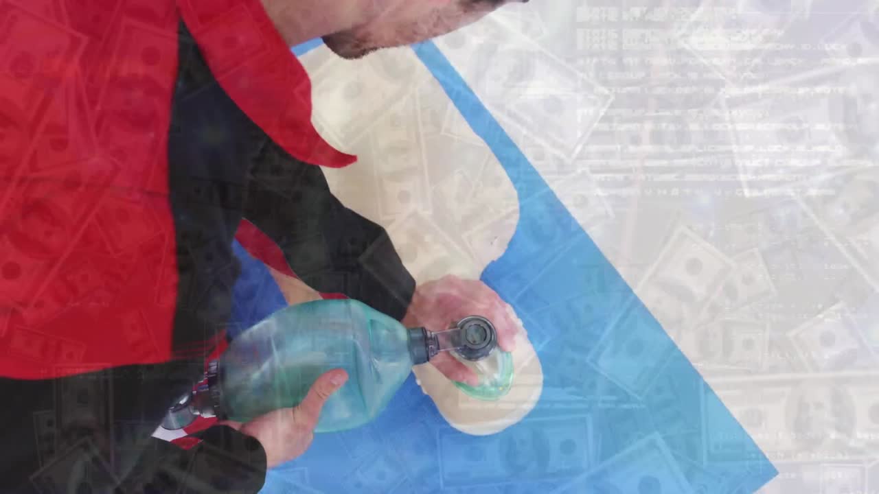 Animation of dollar bills and graphs over caucasian man using bag valve mask on cpr dummy