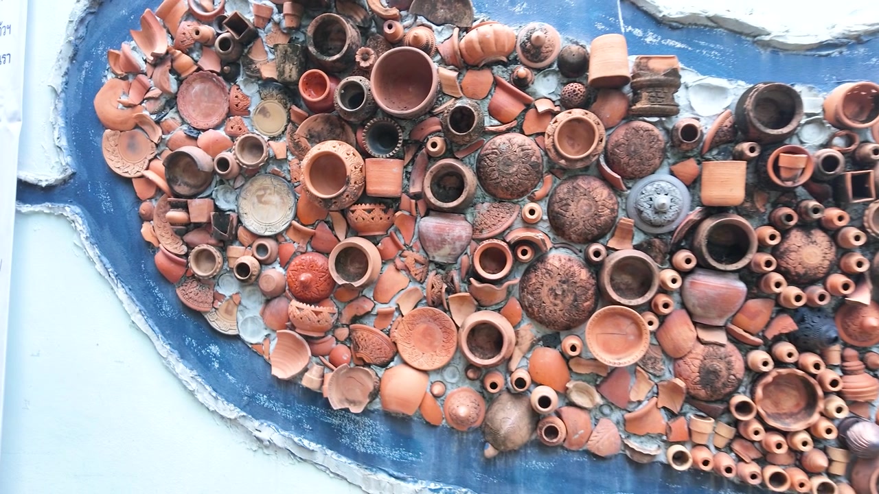 La telecamera si allontana da un intricato mosaico in terracotta su una parete a Koh Kret, Thailandia