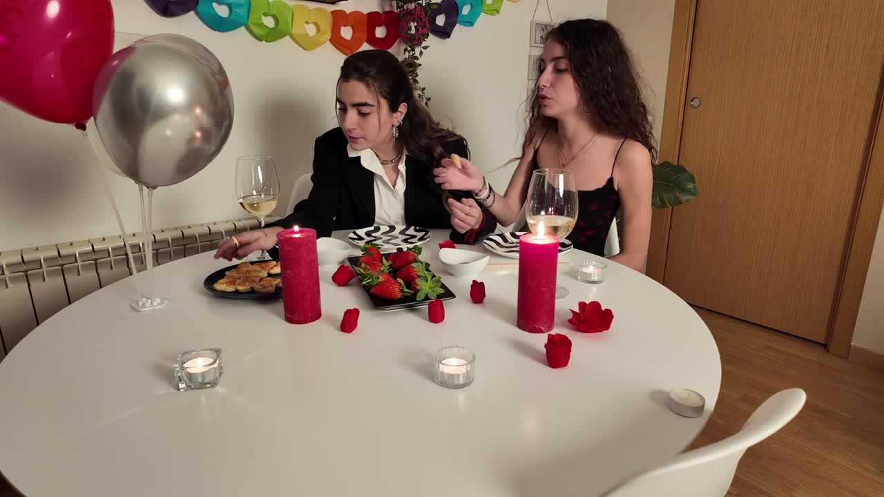 Two women celebrating with a dinner and balloons