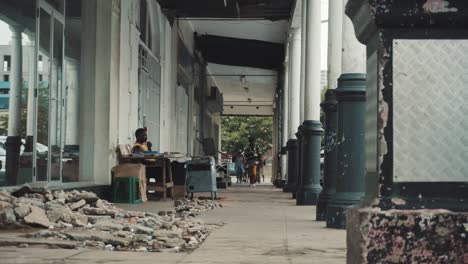 static shot of a man walking down a side walk in the maputo city center. mozambique.