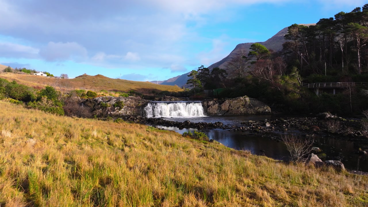 4K Aerial view of Aasleagh Falls highlighting a small waterfall along a river in a remote natural setting. Captures the movement of water and surround._09