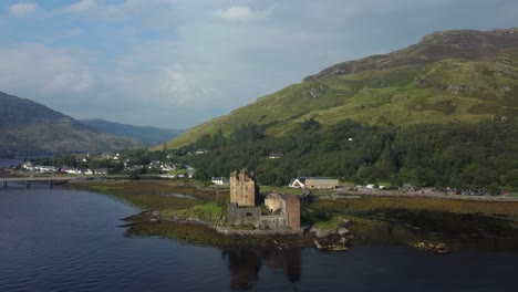 Eilean-Donan-Castle-Im-Hochland-Von-Schottland,-Großbritannien-_-Drohnenaufnahme-Sonnenuntergang-Mit-Wunderschönem-See,-Der-Aus-Der-Ferne-Schiebt