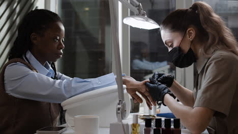 woman getting a manicure at a nail salon