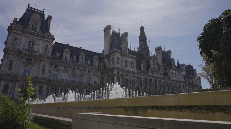 Exterior Of Hotel De Ville In Paris France With Fountains In Foreground In Slow Motion