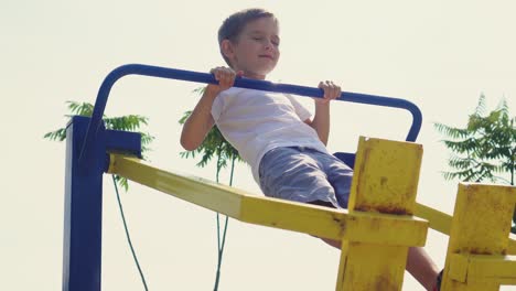 a little boy does sports on the playground 01