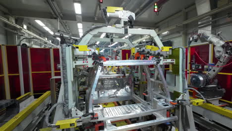 robot arm inspecting an automobile assembly line works in a factory that assembles lithium or sodium batteries used in cars or electric vehicle