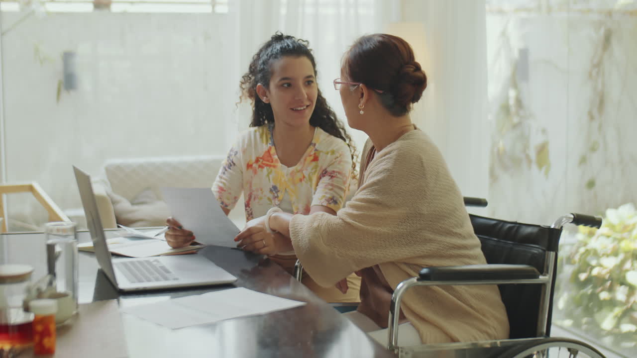 Senior Woman and Young Woman Working Together at Home