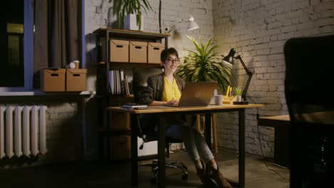 woman working late at night on her laptop in a modern home office