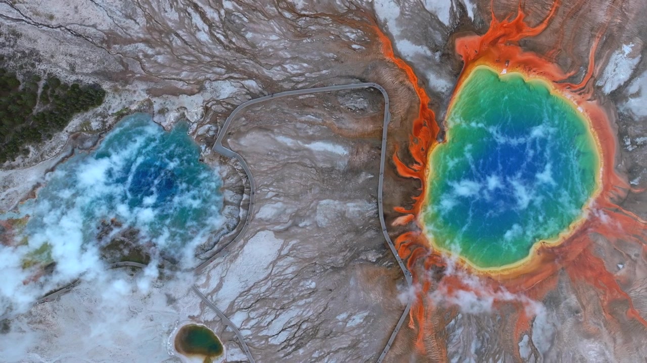 Grand Prismatic Springsin altaat, lintuperspektiivistä otettu ilmakuva dronella Mid Geyser Basinista, Fairy Fallsin polun lankkupolku, Wyomingin Yellowstonen kansallispuisto. Aamun värikkäät kuumat lähteet höyryävät luontomaisemassa muodostaen ylöspäin nousevan ympyrän.