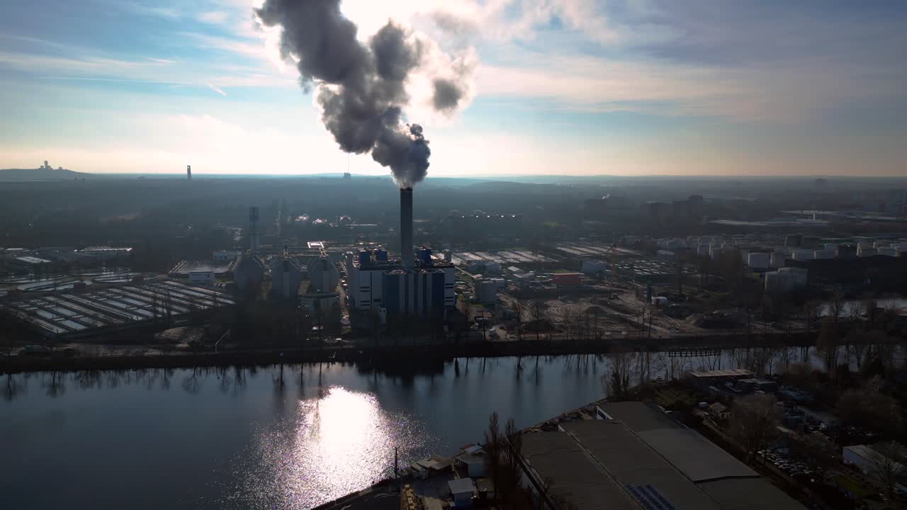 large industrial power plant emitting large amounts of smoke over the city Berlin next to a river on a sunny day. Lovely aerial view flight panorama overview drone