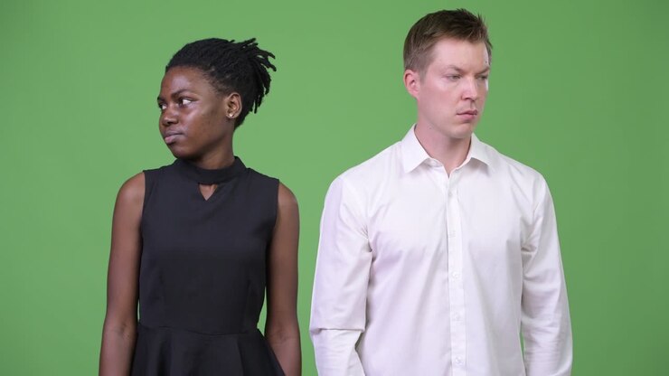Two young multi-ethnic business couple looking in opposite directions together
