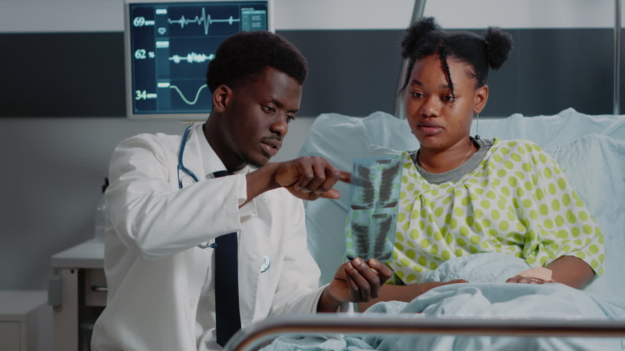 Man working as doctor analyzing x ray scan with sick patient